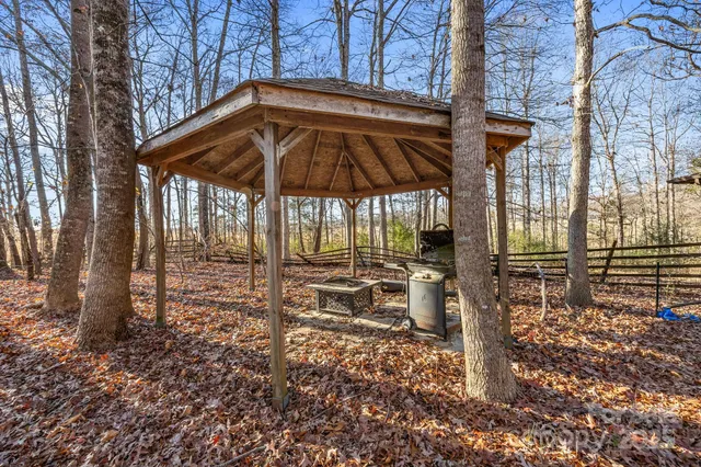 a view of a backyard with table and chairs under an umbrella