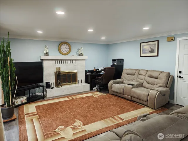 a living room with furniture a flat screen tv and wooden floor
