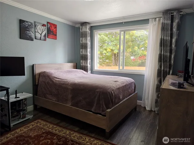 a view of a bedroom with wooden floor and closet