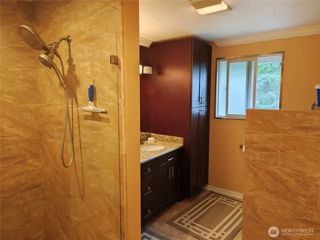 a bathroom with a granite countertop sink a mirror and shower