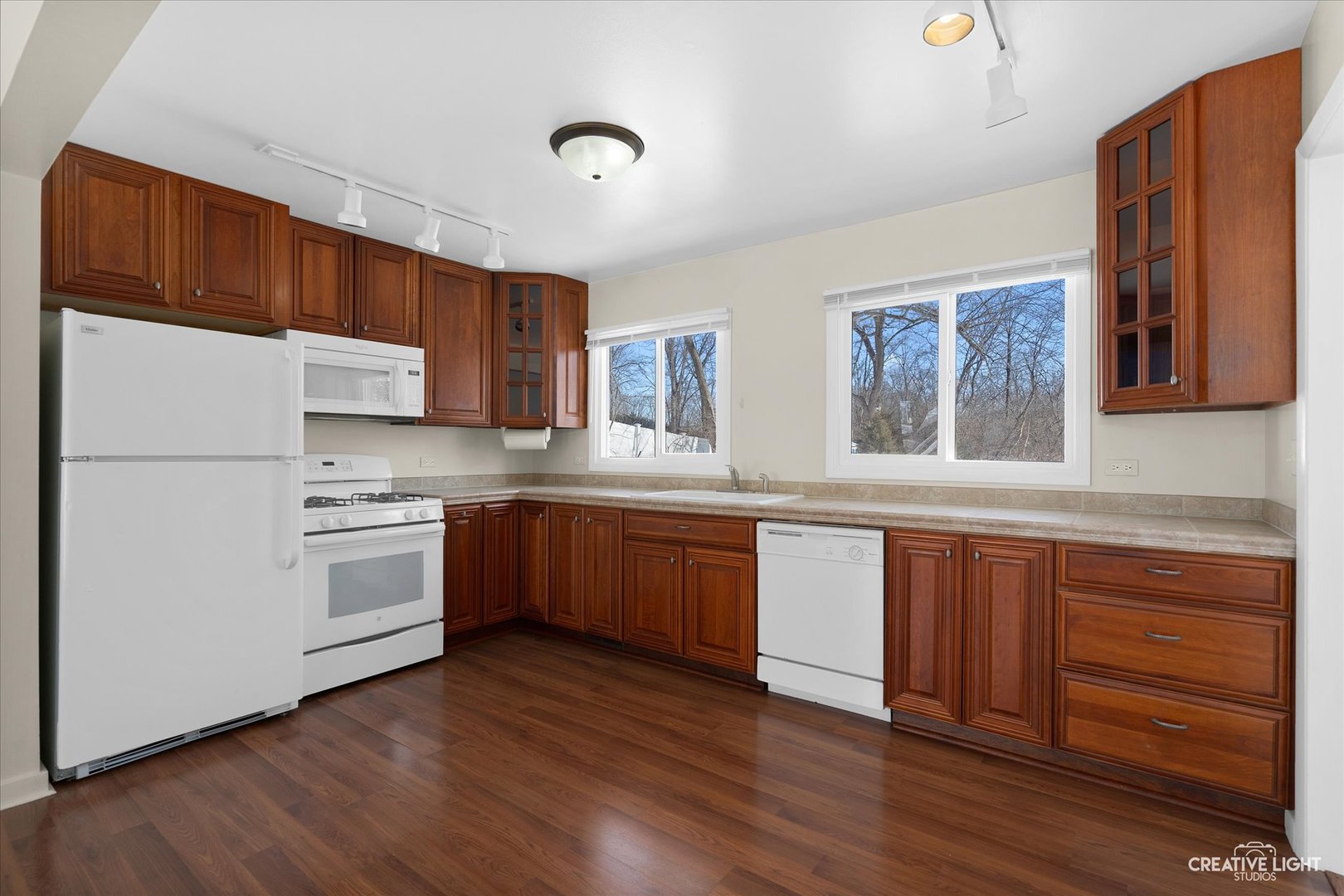 5S621 Radcliff Road Naperville, IL 60563 - Photo 11 of 27 a kitchen with granite countertop wooden floors a stove and white stainless steel appliances