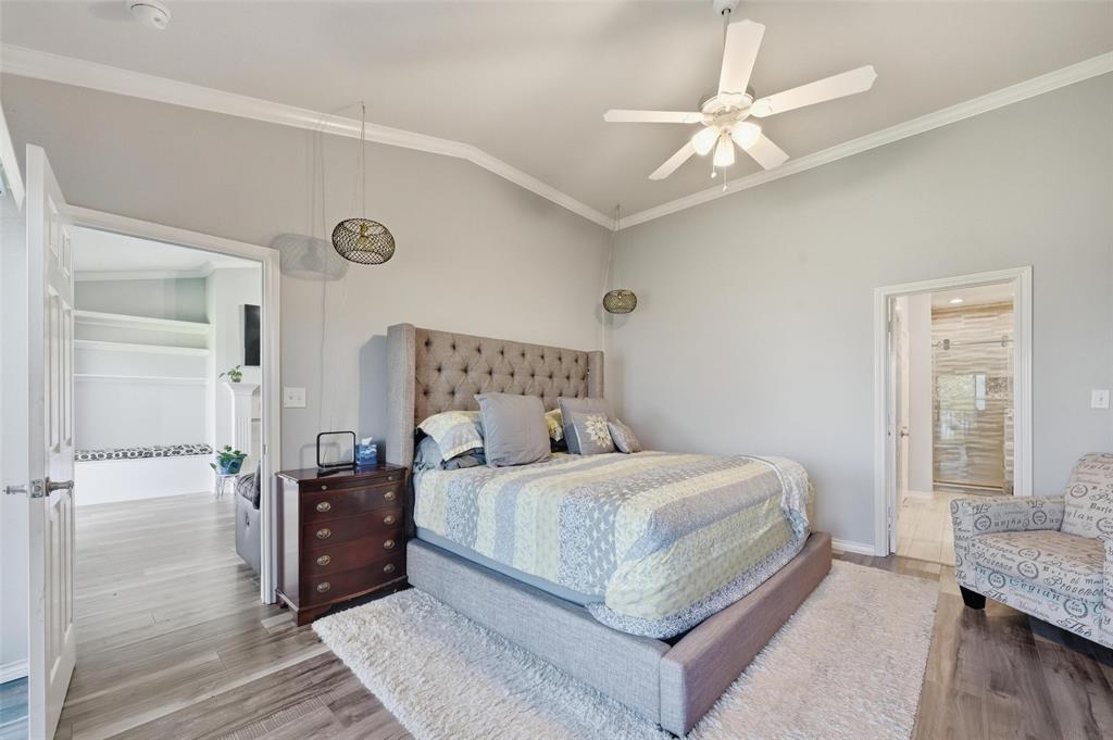 1904 Signal Ridge Place Rockwall, TX 75032 - Photo 17 of 23 Bedroom with ornamental molding, lofted ceiling, wood finished floors, and ceiling fan