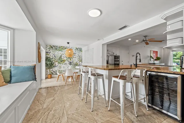 a dining room with furniture and a large window