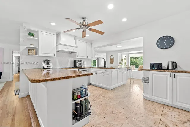 a large kitchen with granite countertop a sink a counter top space and stainless steel appliances