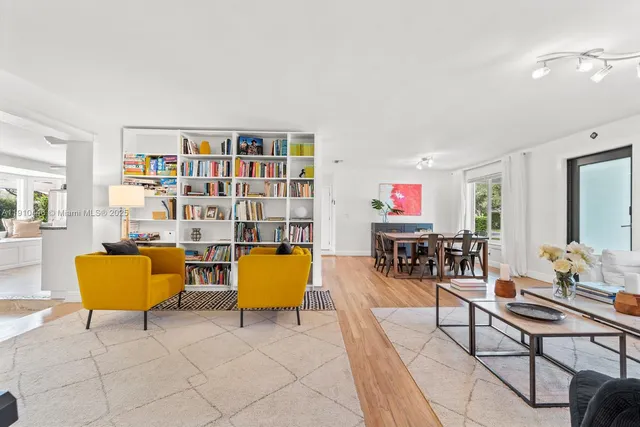 a living room with furniture a rug and a bookshelf