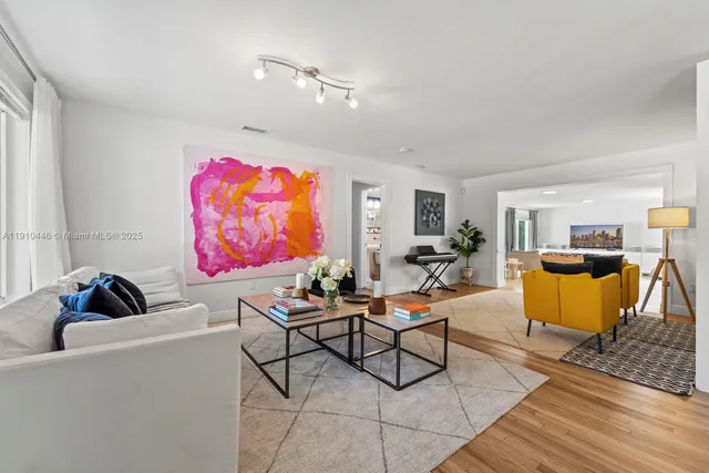 a living room with furniture a rug and a wall painting