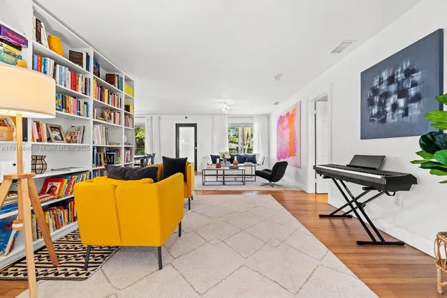 a living room with furniture a flat screen tv and a book shelf