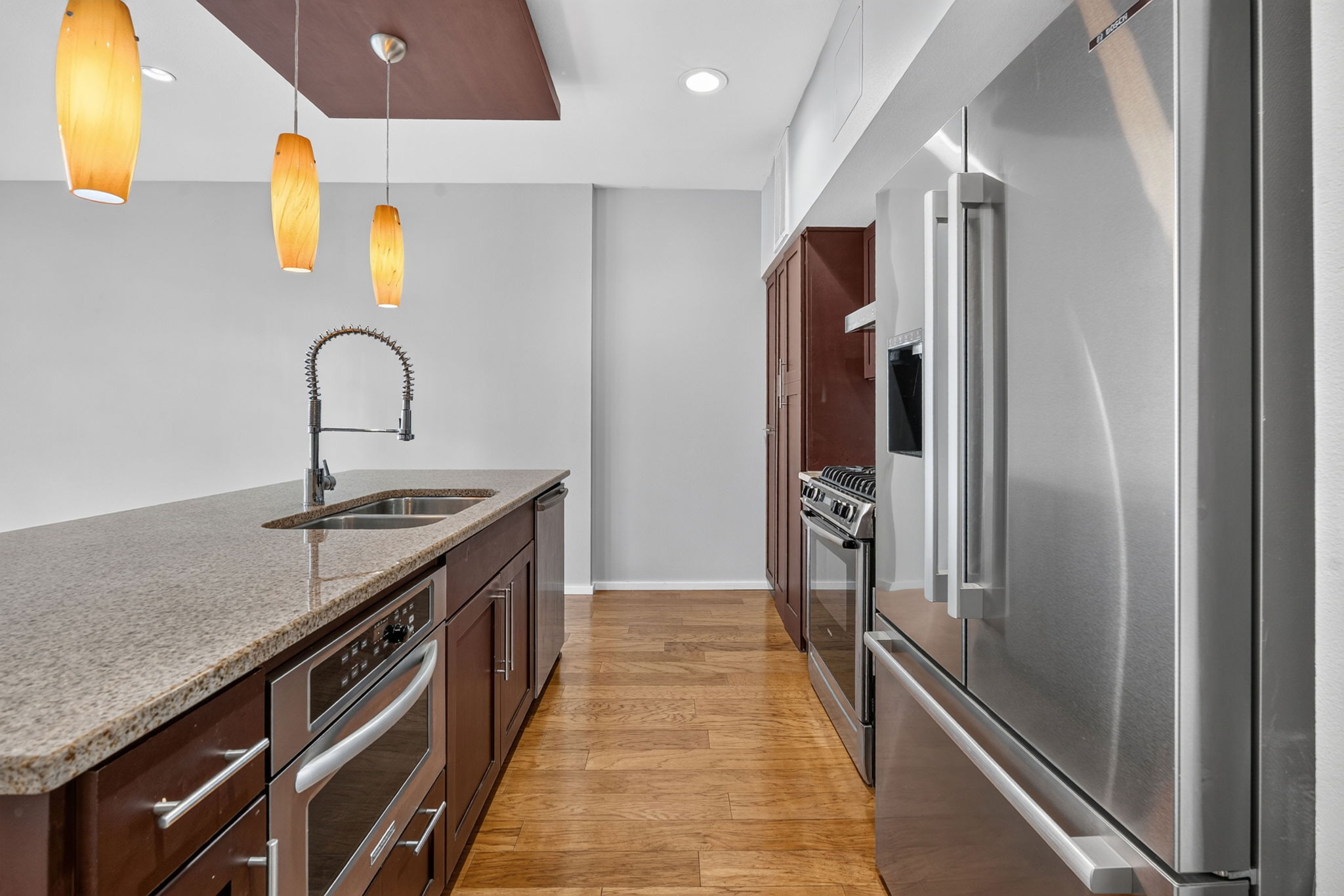 1600 Barton Springs Road, Unit 1302 Austin, TX 78704 - Photo 10 of 15 Gleaming hardwood floors complement granite countertops and professional-grade stainless steel appliances in this kitchen.