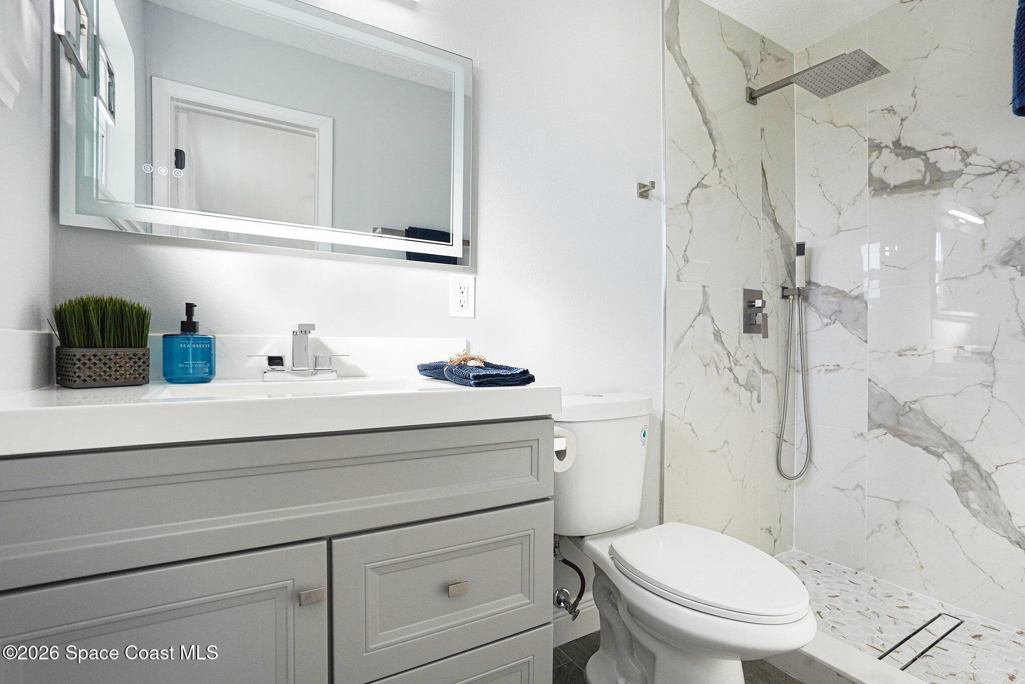 2793 North Breeze Road Melbourne, FL 32935 - Photo 11 of 14 a bathroom with a sink a toilet and shower curtain