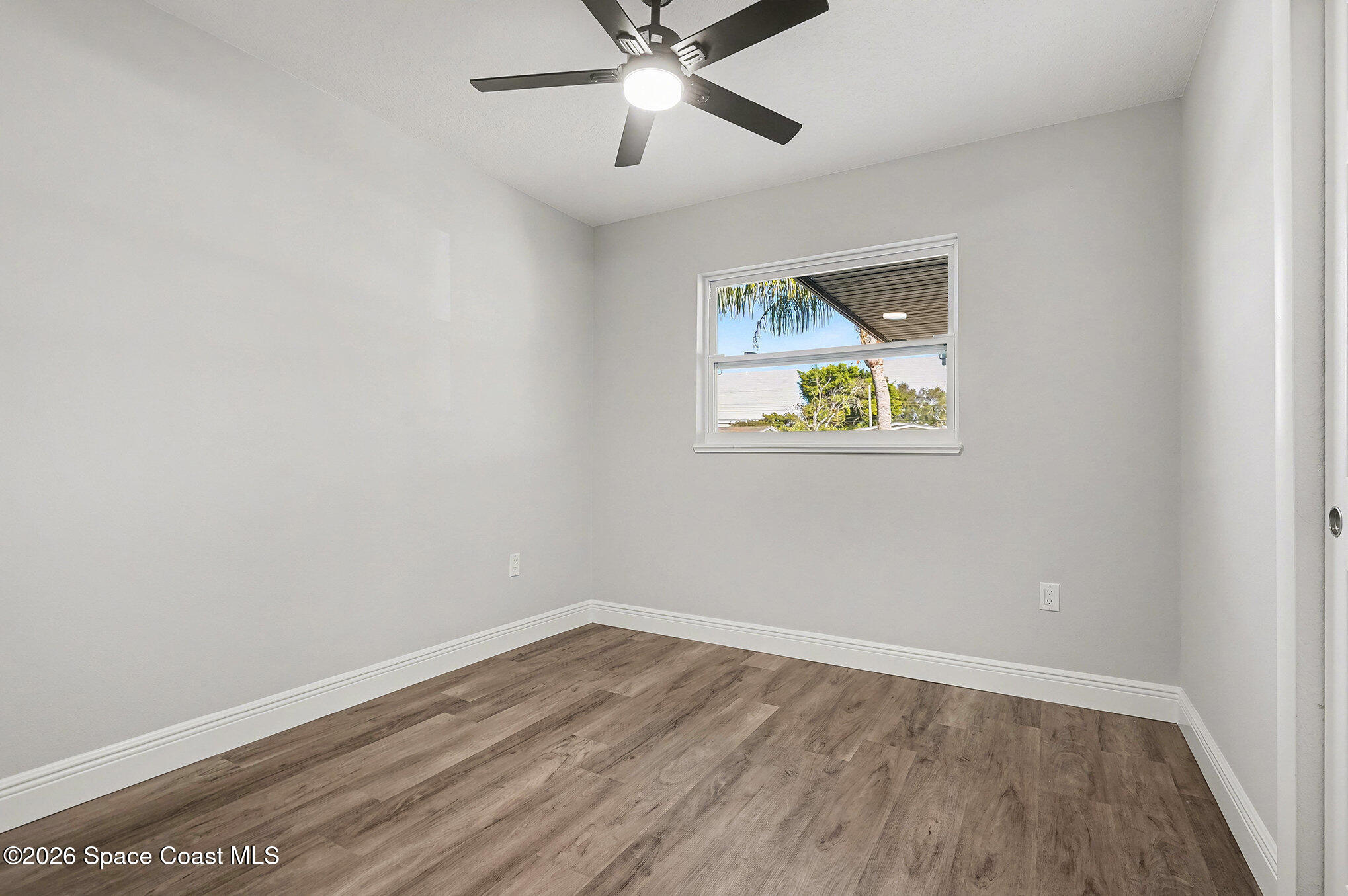 2793 North Breeze Road Melbourne, FL 32935 - Photo 14 of 14 wooden floor in an empty room with a window