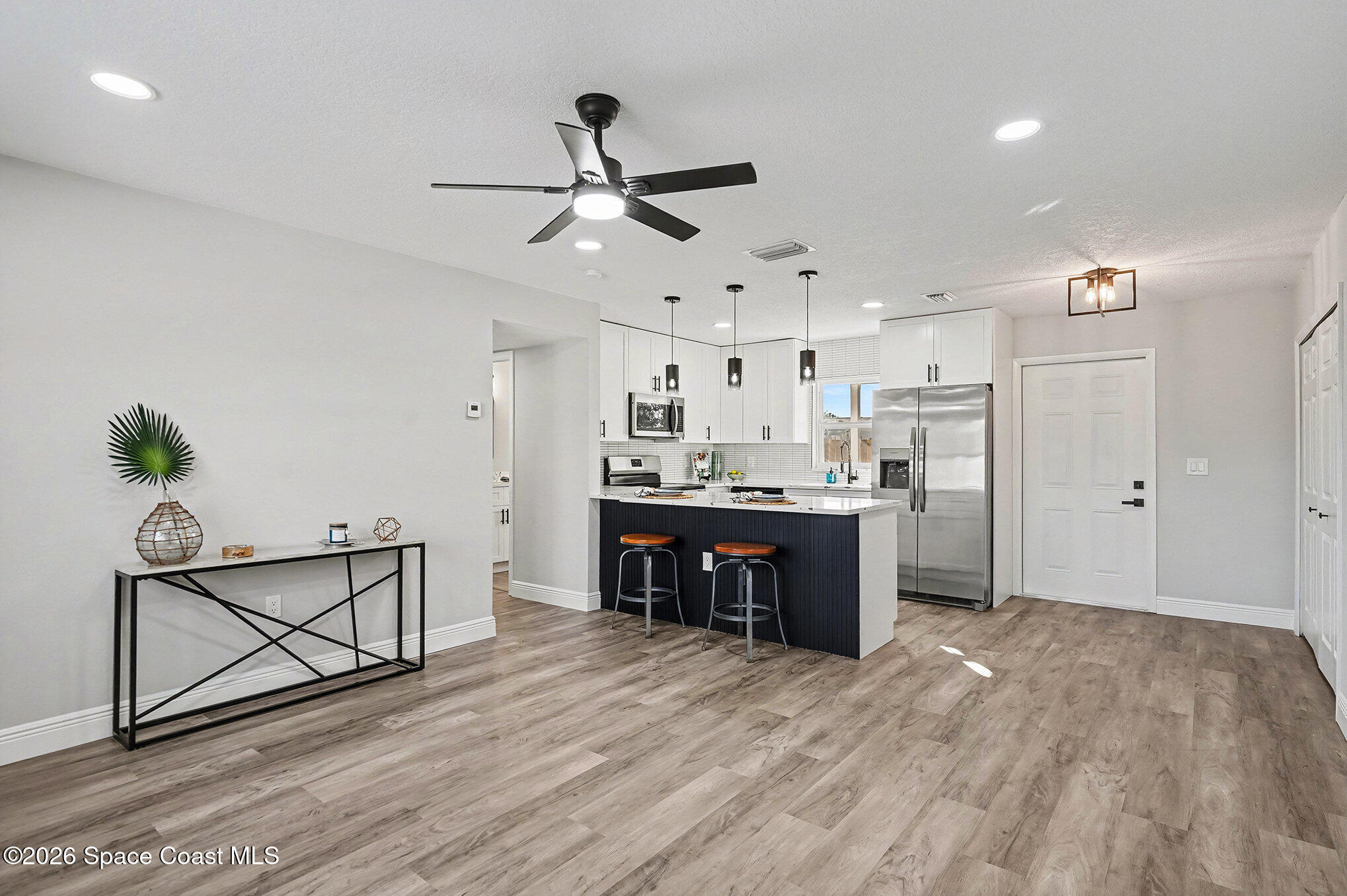 2793 North Breeze Road Melbourne, FL 32935 - Photo 5 of 14 a kitchen with stainless steel appliances kitchen island hardwood floor sink and stove