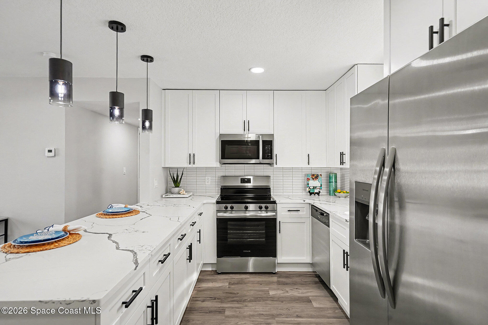 2793 North Breeze Road Melbourne, FL 32935 - Photo 7 of 14 a kitchen with stainless steel appliances a refrigerator sink and stove top oven