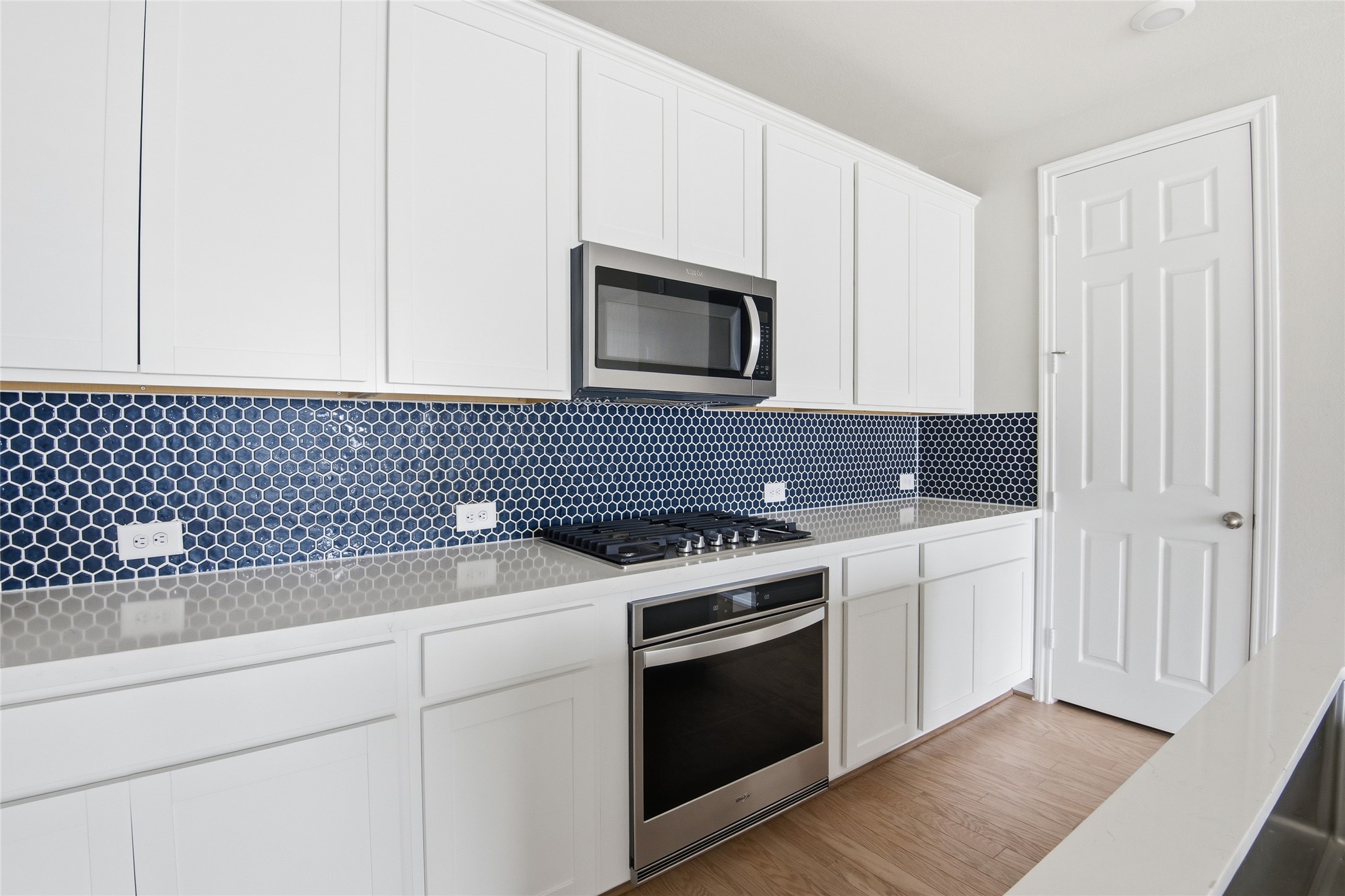9406 Caddo Ridge Lane Cypress, TX 77433 - Photo 9 of 16 a kitchen with granite countertop white cabinets and black appliances