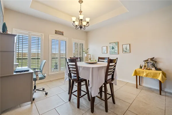 a view of a dining room with furniture and a chandelier
