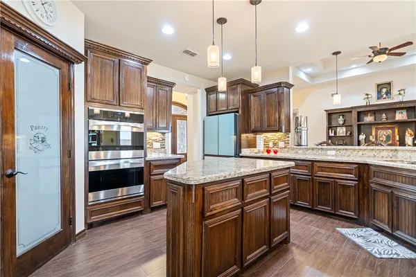 a kitchen with stainless steel appliances granite countertop wooden cabinets and a stove