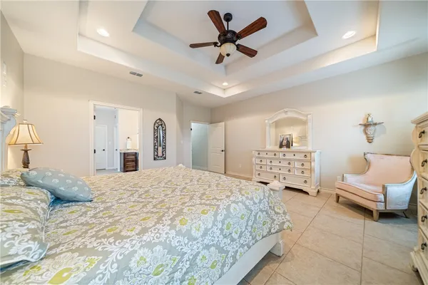 a spacious bedroom with a bed a couch and a chandelier