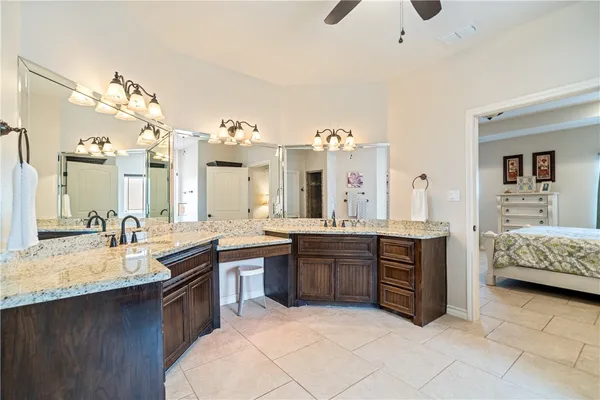 a large bathroom with a granite countertop double vanity sink a mirror and bathtub
