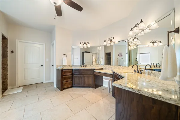 a large kitchen with kitchen island granite countertop a sink and cabinets