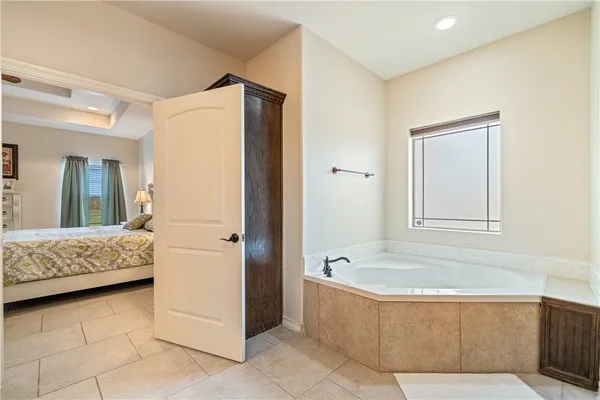 a bathroom with a tub a mirror and a shower