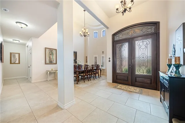 a living room with furniture kitchen view and a chandelier