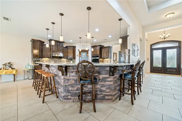 a open kitchen with stainless steel appliances kitchen island granite countertop a table and chairs