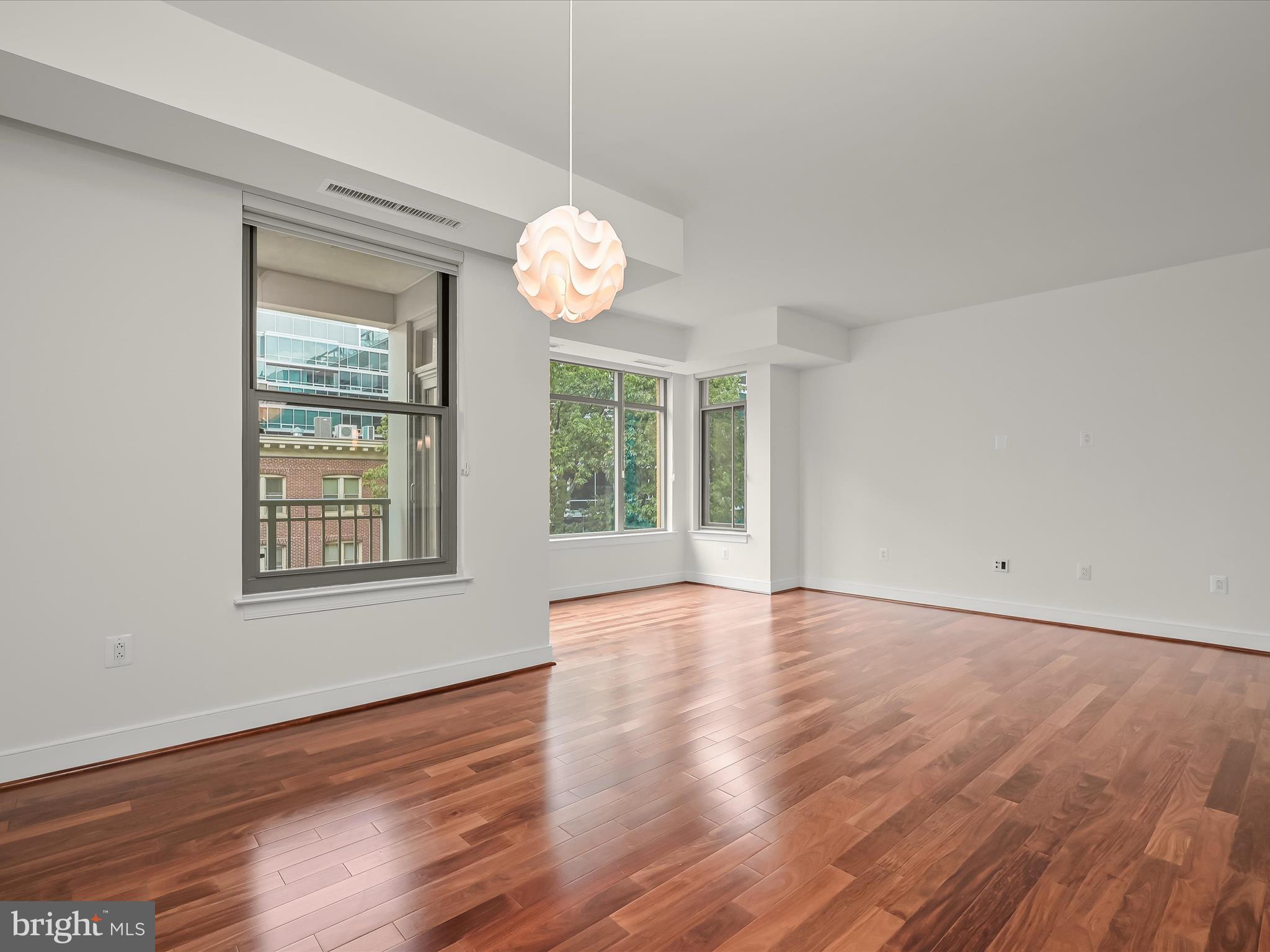 2425 L Street Northwest, Unit 536 Washington, DC 20037 - Photo 11 of 41 an empty room with wooden floor and windows