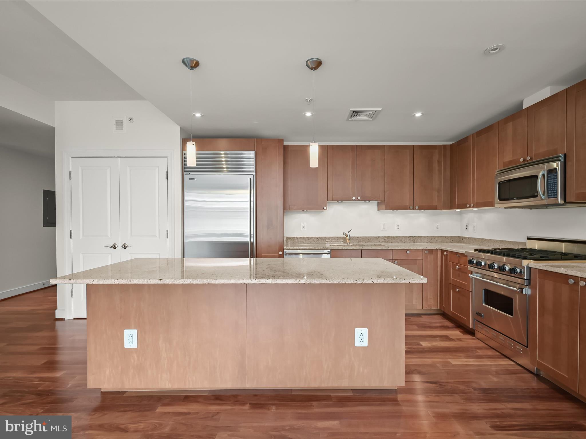 2425 L Street Northwest, Unit 536 Washington, DC 20037 - Photo 13 of 41 a kitchen with kitchen island granite countertop a sink and a stove