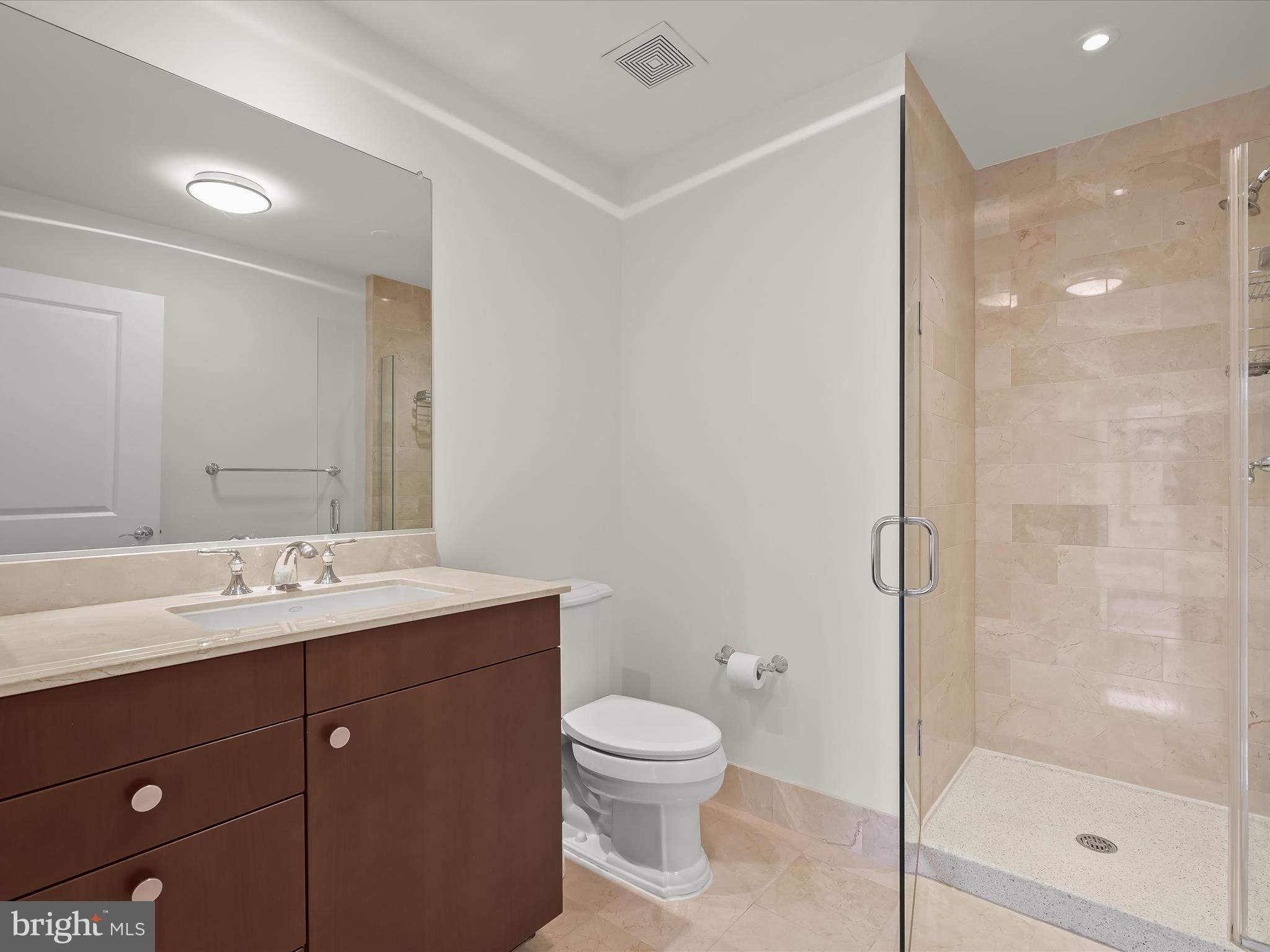 2425 L Street Northwest, Unit 536 Washington, DC 20037 - Photo 24 of 41 a bathroom with a toilet a sink a mirror and shower