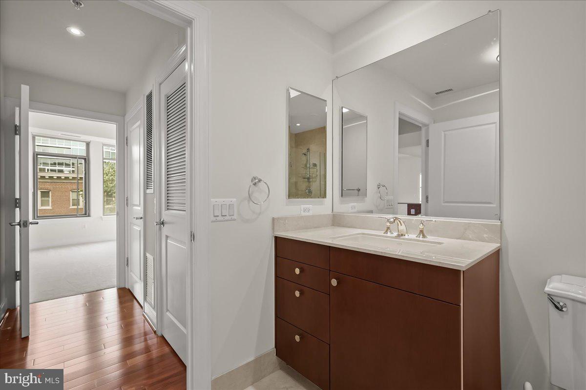 2425 L Street Northwest, Unit 536 Washington, DC 20037 - Photo 25 of 41 a en suite bathroom with a double vanity sink a mirror and a shower