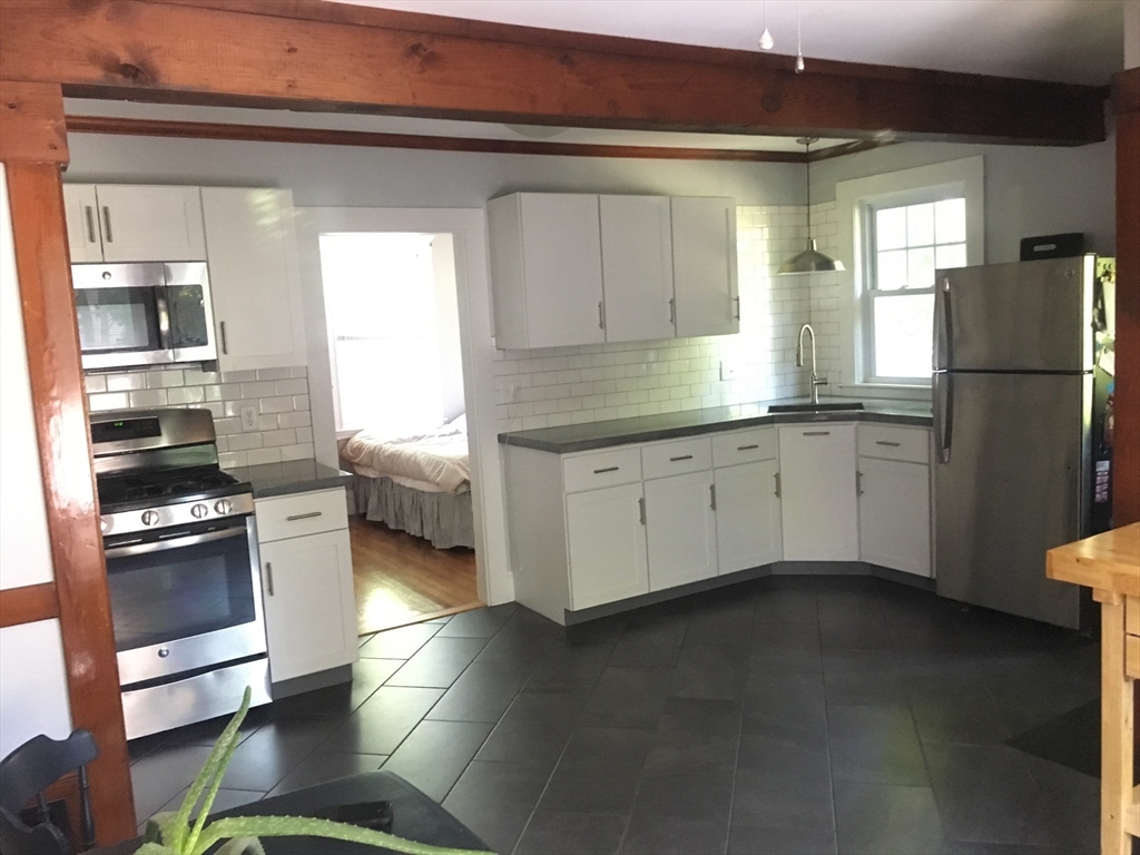 7 Richie Road, Unit 2 Quincy, MA 02169 - Photo 2 of 7 a kitchen with stainless steel appliances a stove a sink and a refrigerator