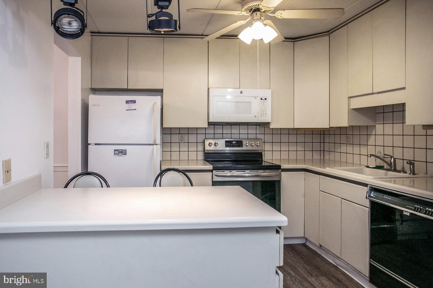 154 Woodstream Drive, Unit CONDO 154 Jeffersonville, PA 19403 - Photo 19 of 34 a kitchen with stainless steel appliances a sink a stove a refrigerator cabinets and a counter top space