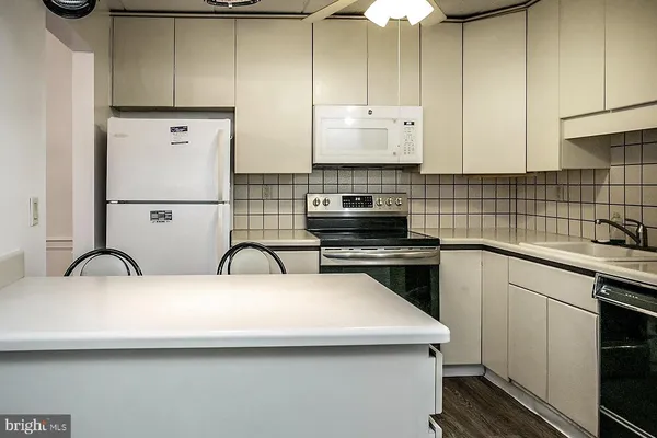 a kitchen with a sink a stove and cabinets