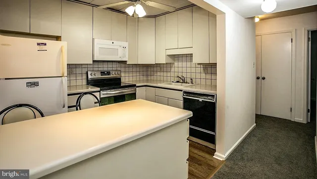 a kitchen with stainless steel appliances a refrigerator sink and white cabinets