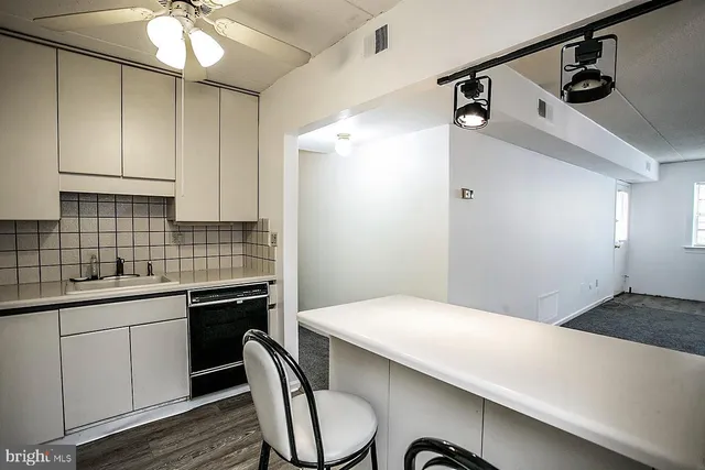 a kitchen with a sink cabinets and wooden floor