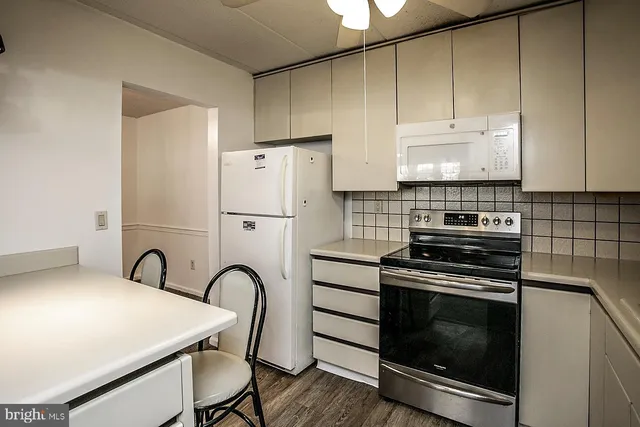 a kitchen with a stove a refrigerator and cabinets