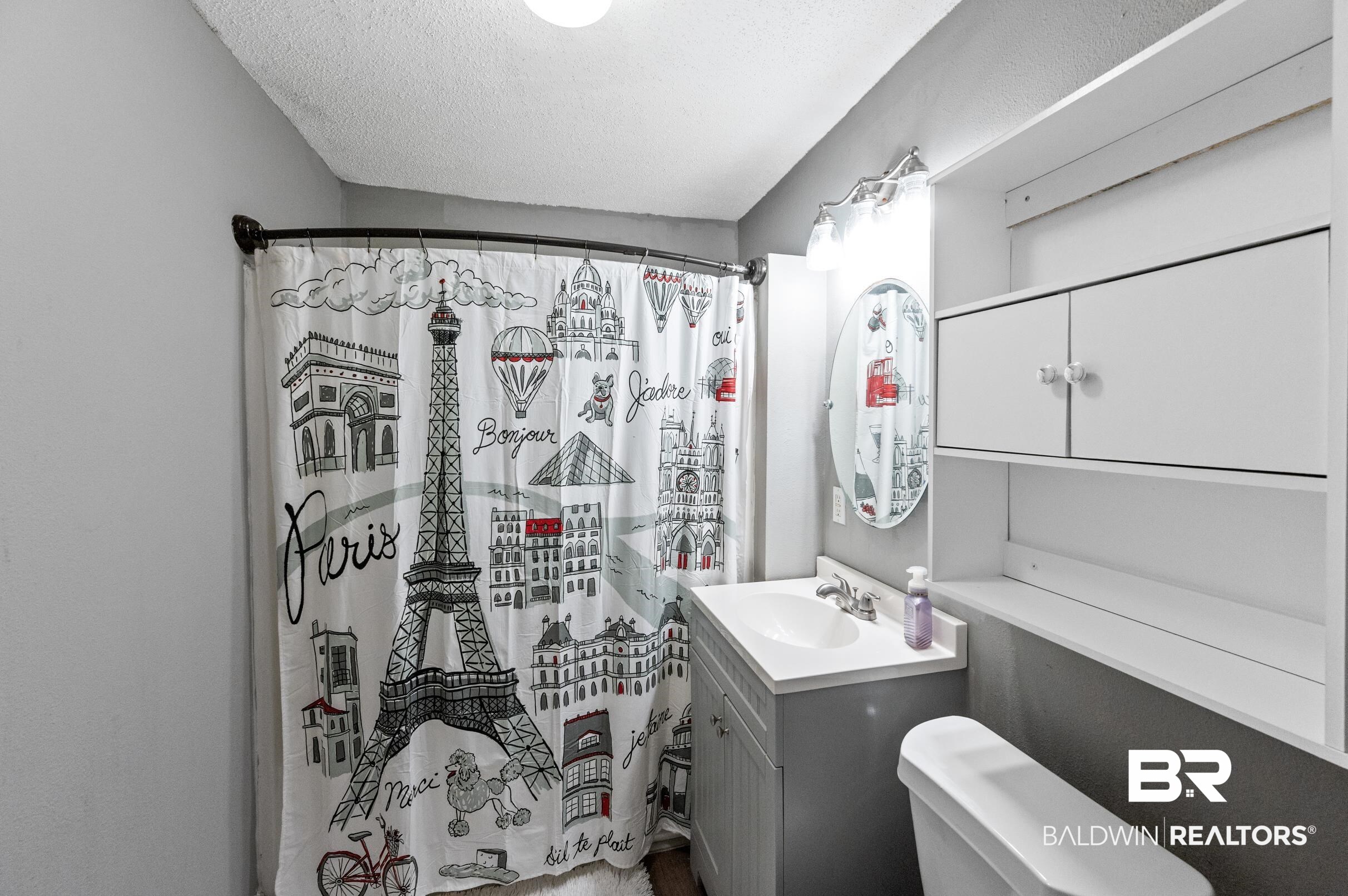 906 North Cedar Street Foley, AL 36535 - Photo 20 of 24 Bathroom with vanity, a textured ceiling, toilet, and a shower with curtain