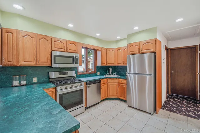a kitchen with stainless steel appliances granite countertop a refrigerator a stove top oven and sink