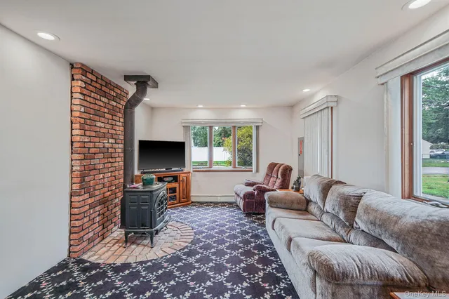 a living room with furniture a window and a flat screen tv