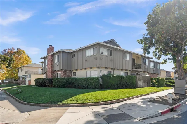a front view of a house with a yard and trees
