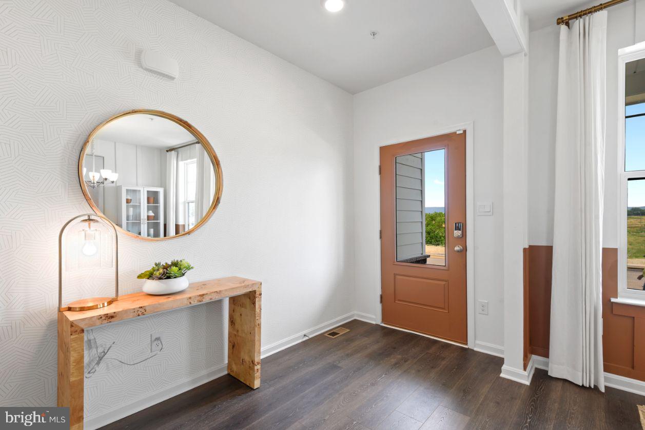 453 Ensemble Way Frederick, MD 21701 - Photo 3 of 34 an entryway with wooden floor and mirror