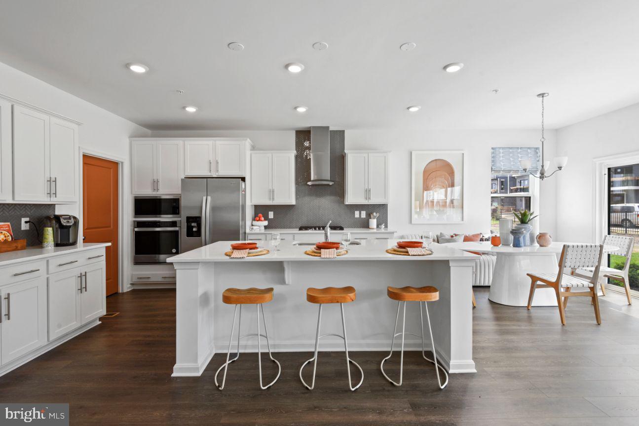 453 Ensemble Way Frederick, MD 21701 - Photo 6 of 34 a kitchen with a dining table chairs refrigerator and cabinets