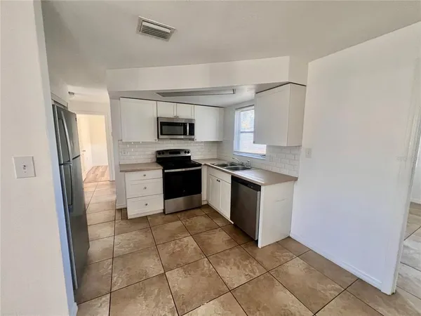 a kitchen with a stove a sink and a refrigerator