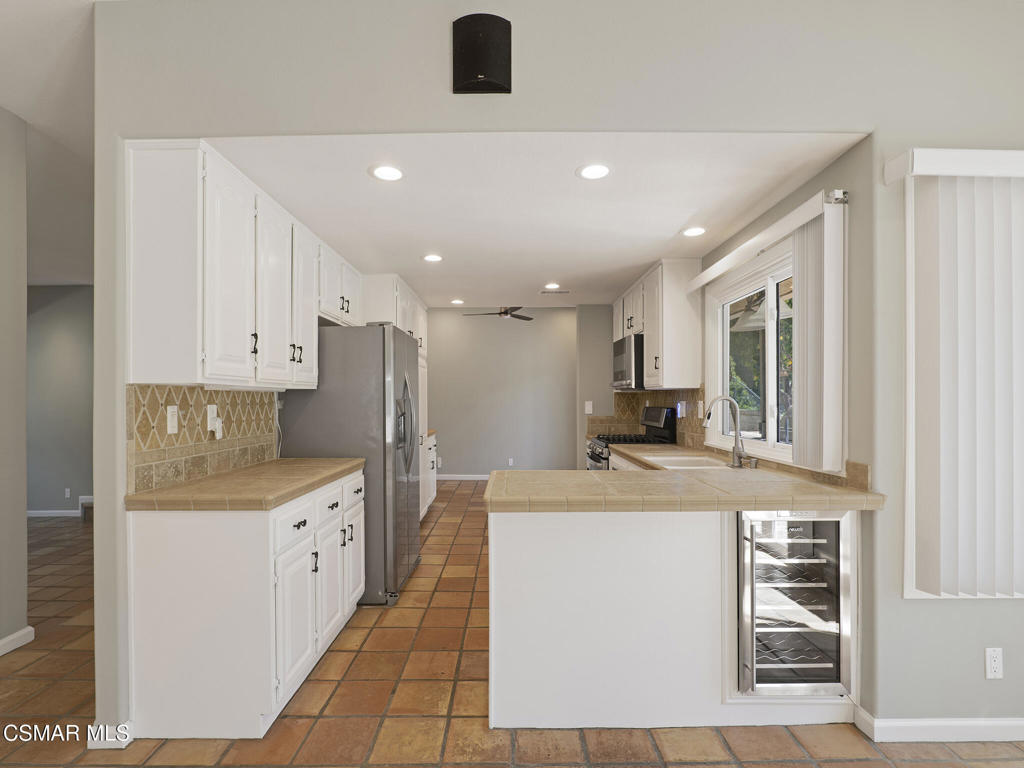 1590 Meander Drive Simi Valley, CA 93065 - Photo 12 of 57 a kitchen with stainless steel appliances kitchen island granite countertop a refrigerator and a stove top oven