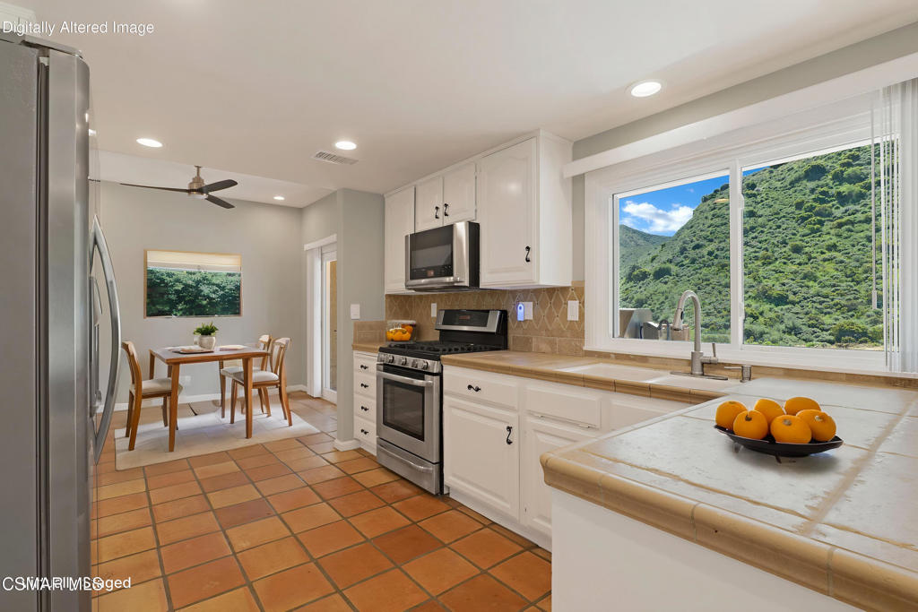 1590 Meander Drive Simi Valley, CA 93065 - Photo 13 of 57 a kitchen with stainless steel appliances granite countertop a stove a sink and a microwave