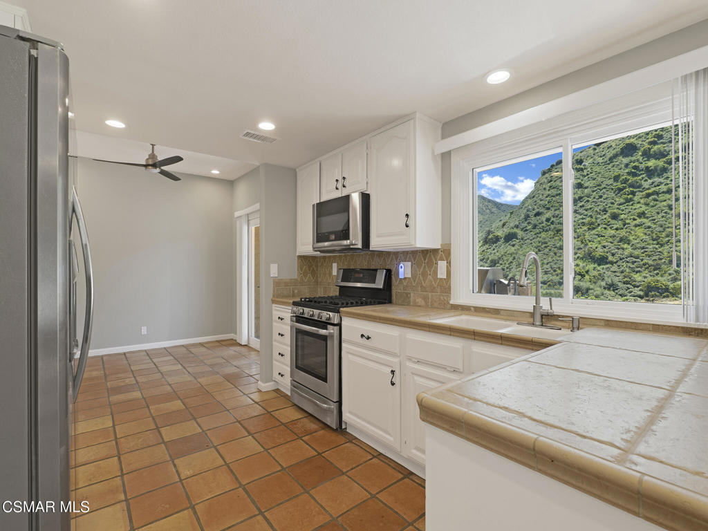 1590 Meander Drive Simi Valley, CA 93065 - Photo 14 of 57 a kitchen with stainless steel appliances granite countertop a refrigerator and a stove top oven