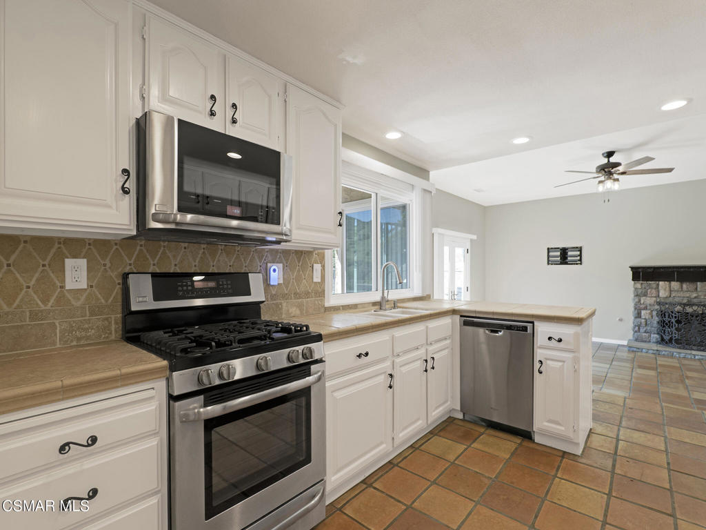 1590 Meander Drive Simi Valley, CA 93065 - Photo 16 of 57 a kitchen with stainless steel appliances a stove sink microwave and cabinets