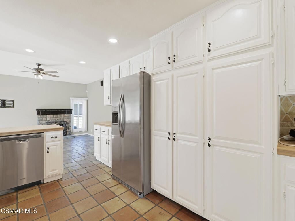 1590 Meander Drive Simi Valley, CA 93065 - Photo 17 of 57 a kitchen with white cabinets and stainless steel appliances