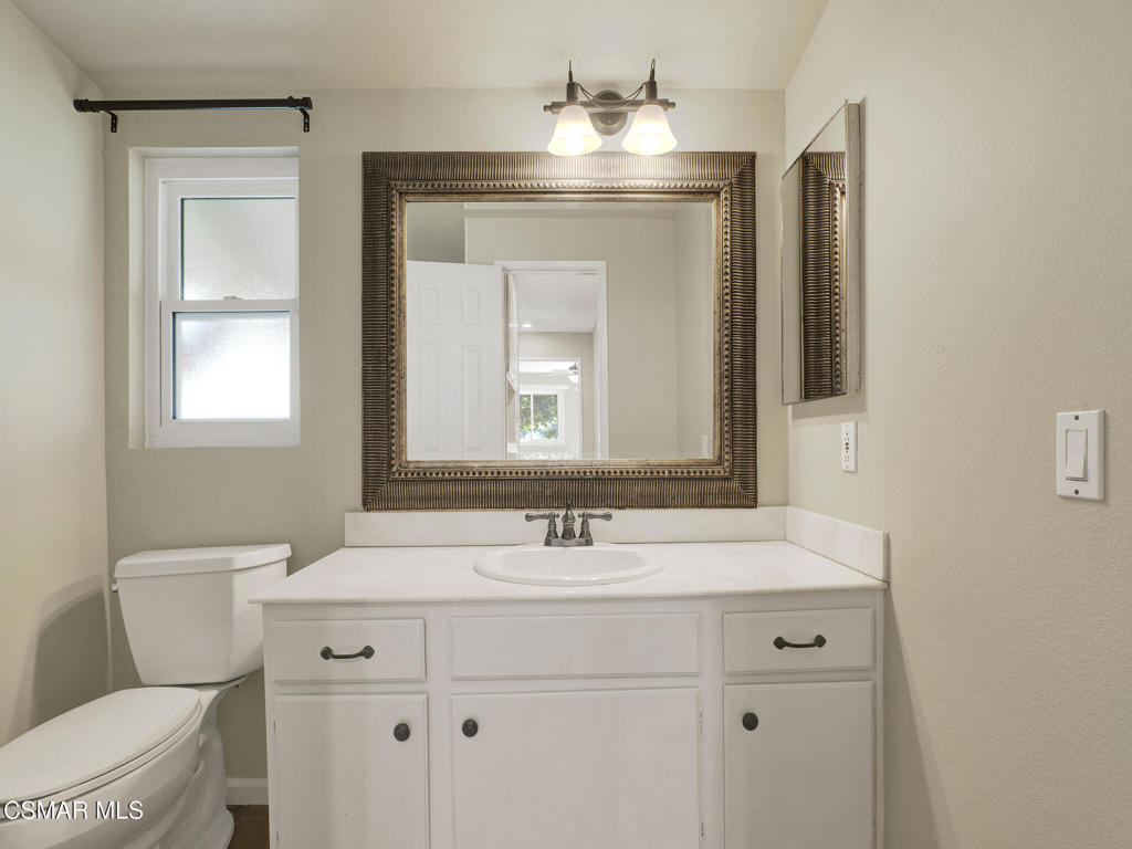 1590 Meander Drive Simi Valley, CA 93065 - Photo 31 of 57 a bathroom with a toilet sink and mirror