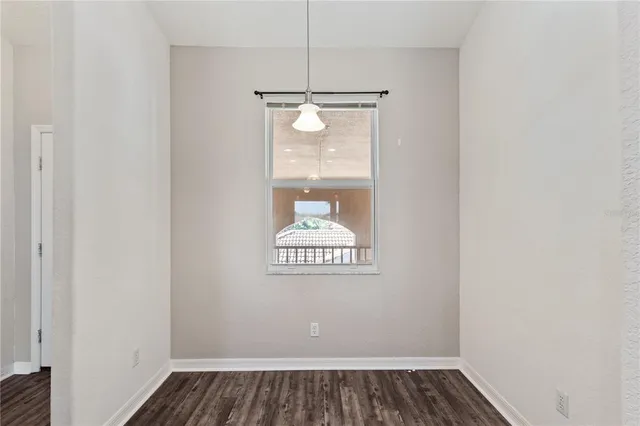 an empty room with wooden floor and a ceiling fan