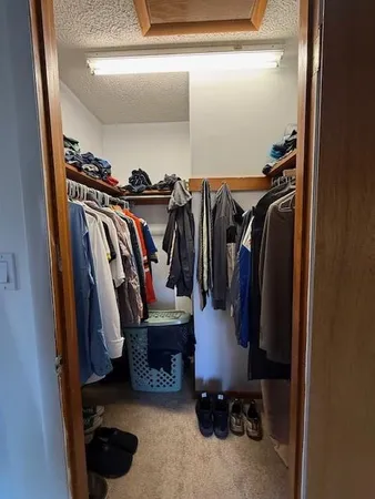 a view of walk in closet with clothes and shoes